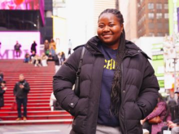 UM student smiling, standing in Times Square